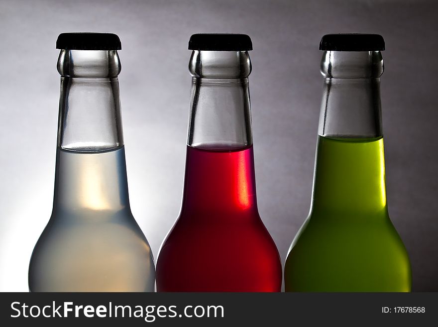 Three colorful bottle of drink on light background