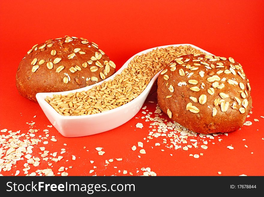 Two pastries with oat seeds on red background