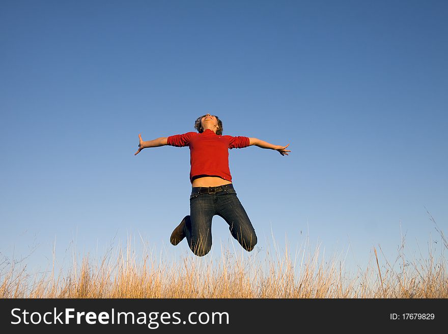 Jumping woman on a sunny day against a blue sky