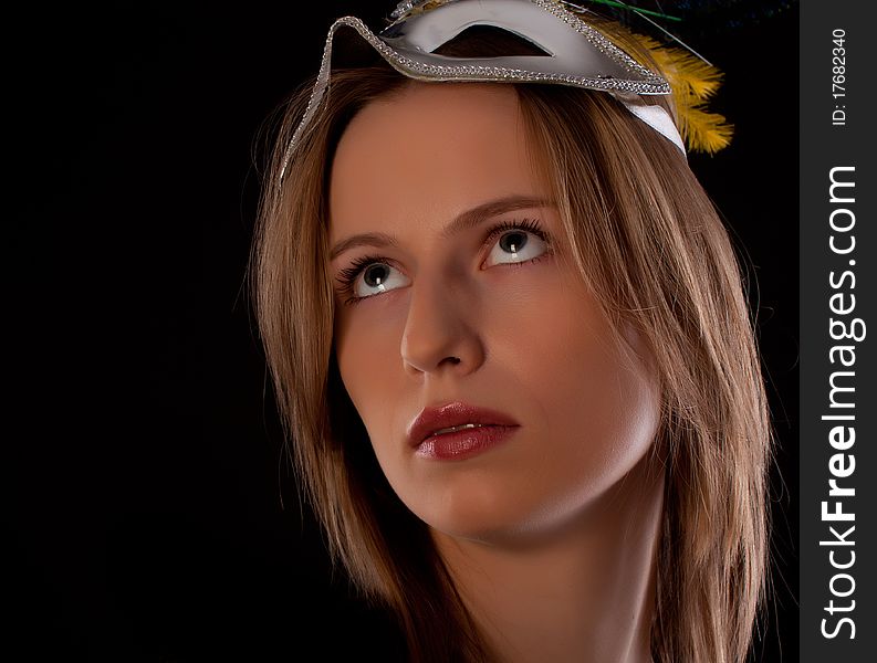 Young woman actor face with mask on black background