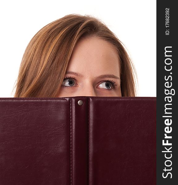 Young woman hides her mouth behind the book on white background