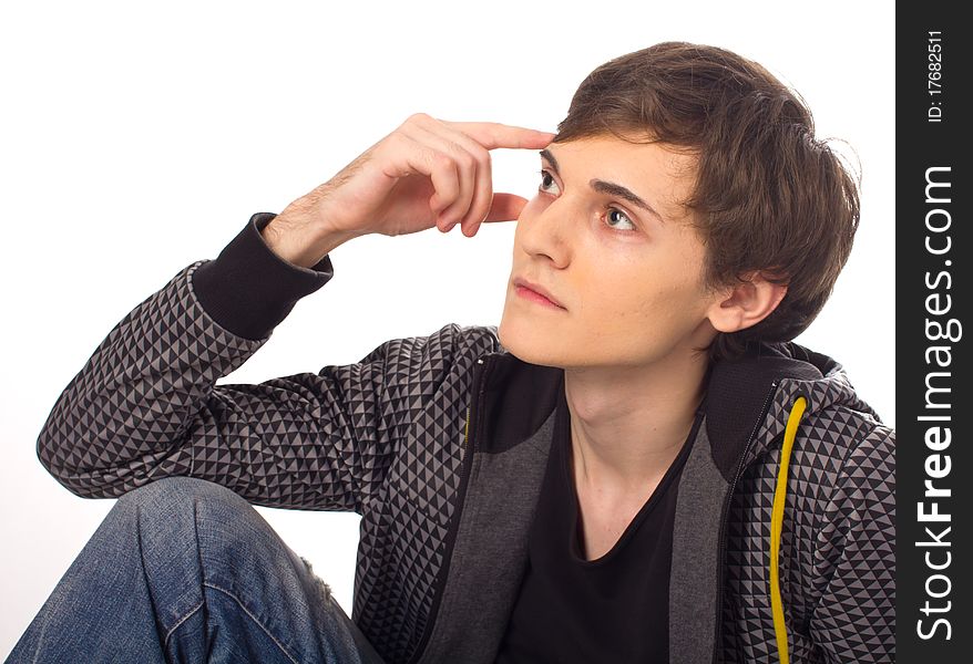 Handsome young man sitting and thinking on white background