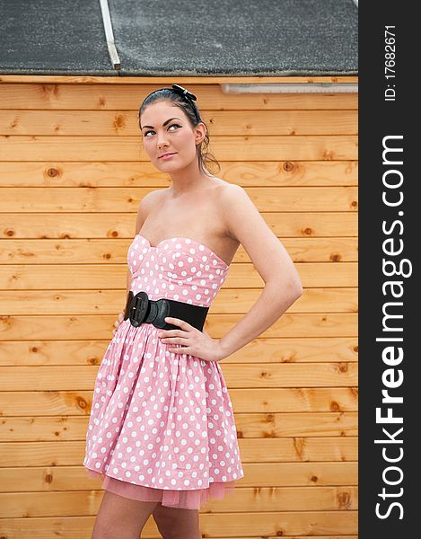 Beautiful and natural young woman wearing a modern pink dress with accessory like belt and headband. Beautiful and natural young woman wearing a modern pink dress with accessory like belt and headband.