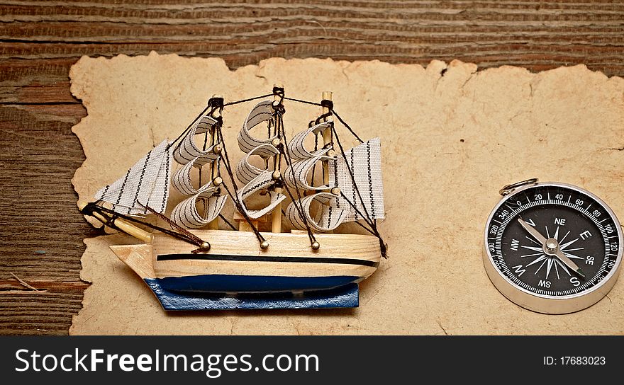 Old paper, compass, and model classic boat