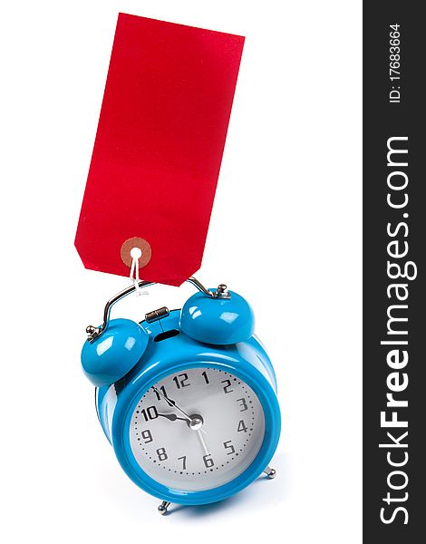 Blue alarm clock with a blank red luggage tag stuck to. Blue alarm clock with a blank red luggage tag stuck to