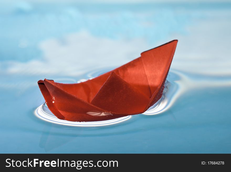 Red paper boat on blue water. Red paper boat on blue water