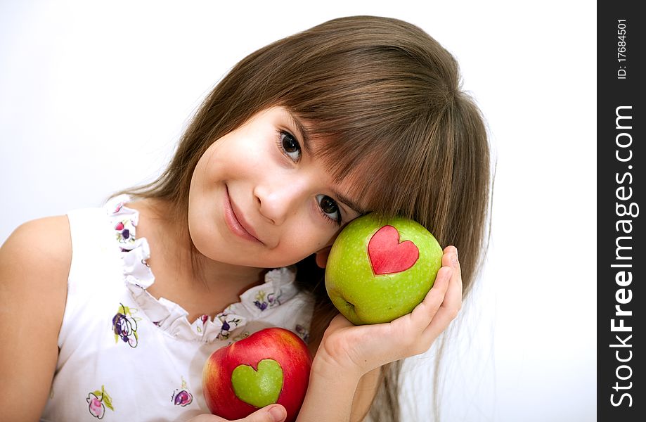 The girl holds two apples with hearts. The girl holds two apples with hearts