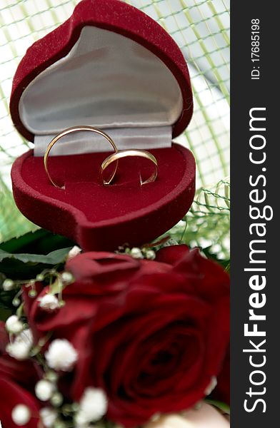 Wedding Rings On Bouquet Of Red Roses