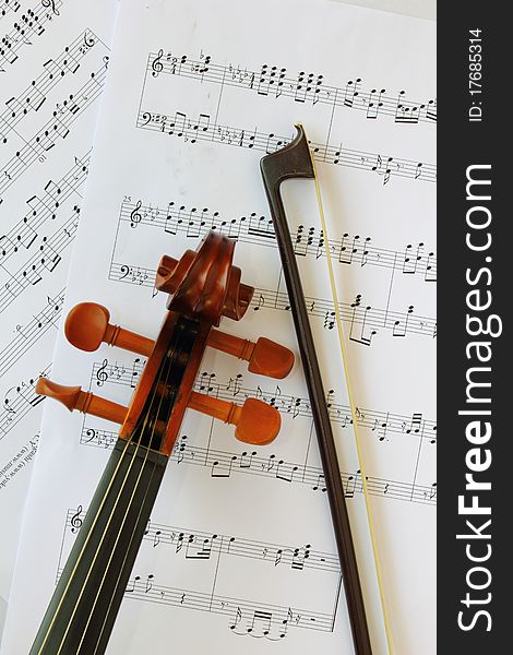 Violin head and neck on music sheet