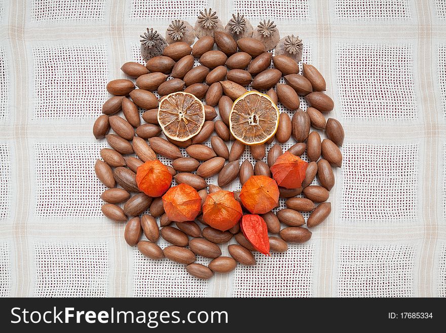 Emoticon face made from dry fruits, nuts and ground-cherry flowers.