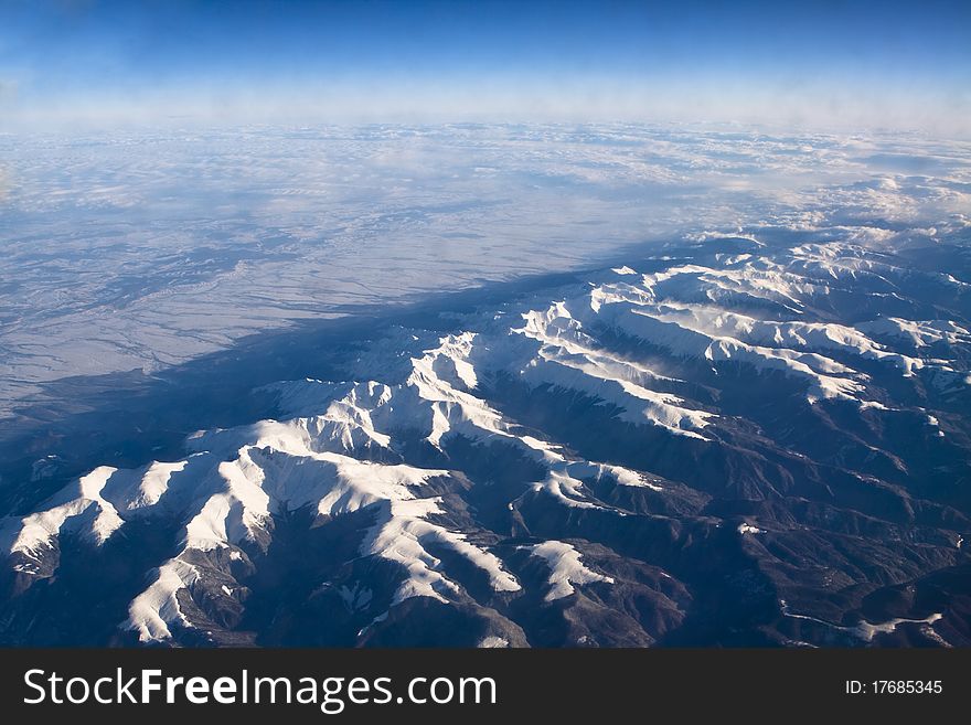 Rocky mountains covered with snow aerial view from airplane
