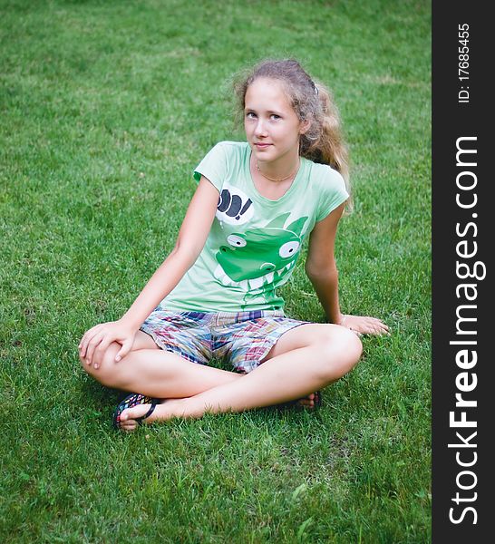 A young girl on green grass
