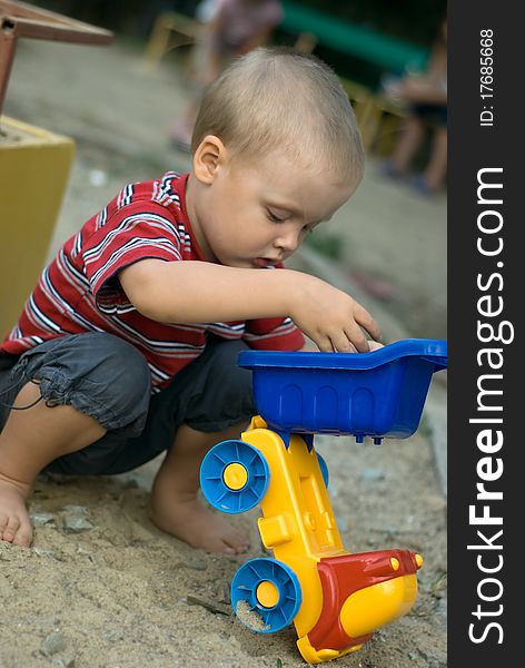 A little boy playing with a car