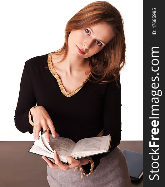 Pretty young woman teacher trainee leafs her textbook on white background. Pretty young woman teacher trainee leafs her textbook on white background