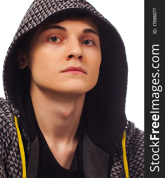 Serious young man standing and looking at you head covered with hood on white background