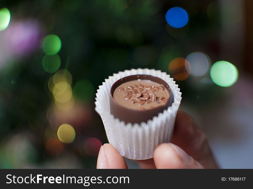 Chocolate candy filled with Christmas lights on the background. Chocolate candy filled with Christmas lights on the background