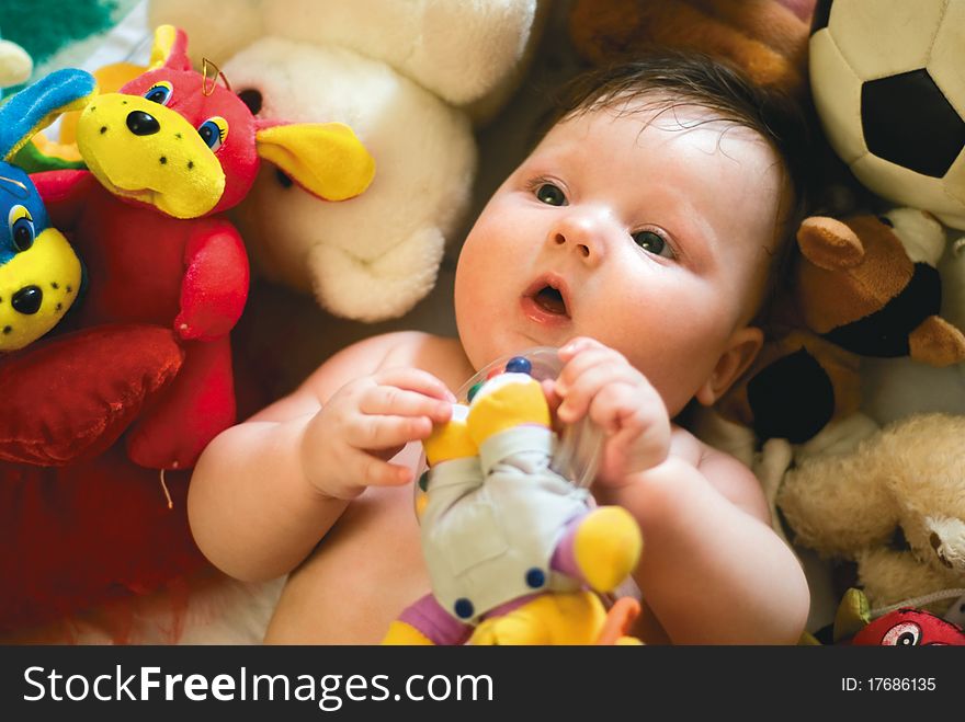 A baby surrounded by toys
