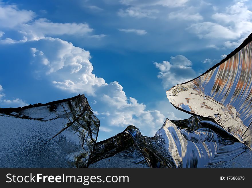 The broken television glass screen against the sky and clouds. The broken television glass screen against the sky and clouds