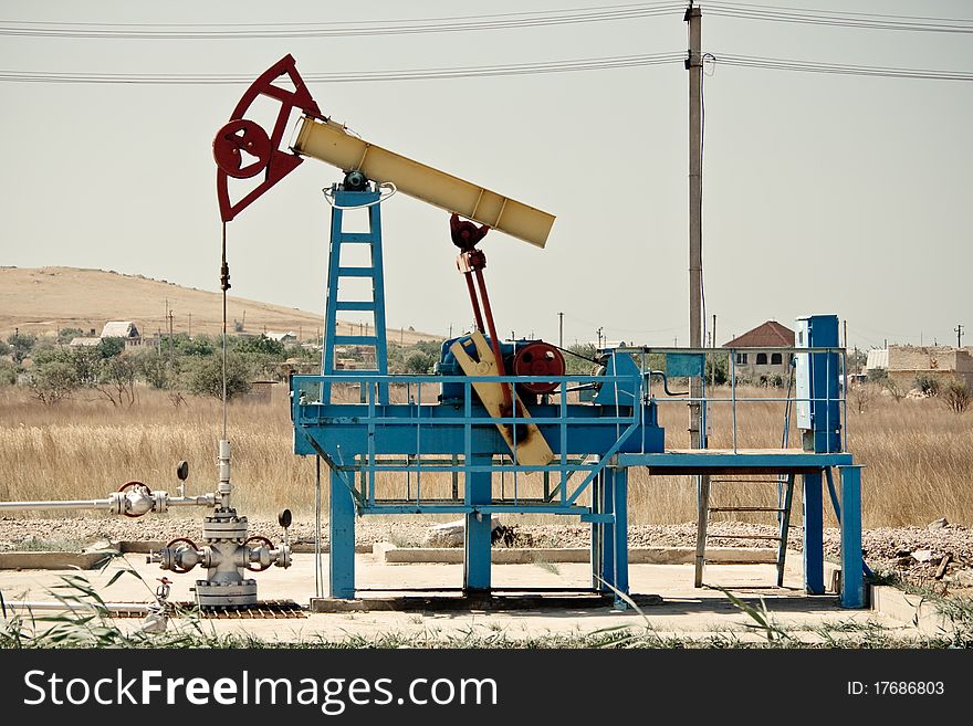 An oil pump jack against clean sky.