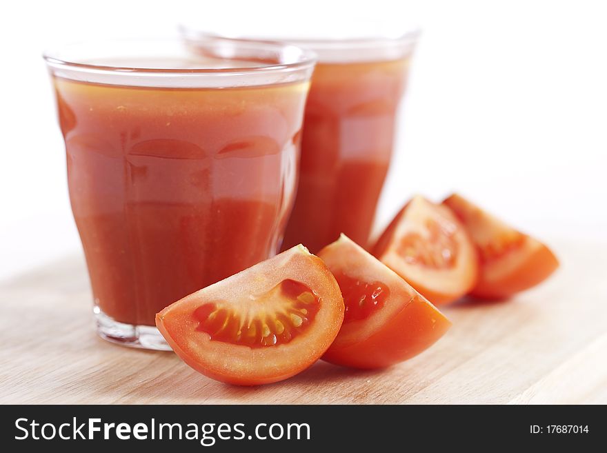 Fresh tomatoes and two glasses full of tomato juice. Fresh tomatoes and two glasses full of tomato juice