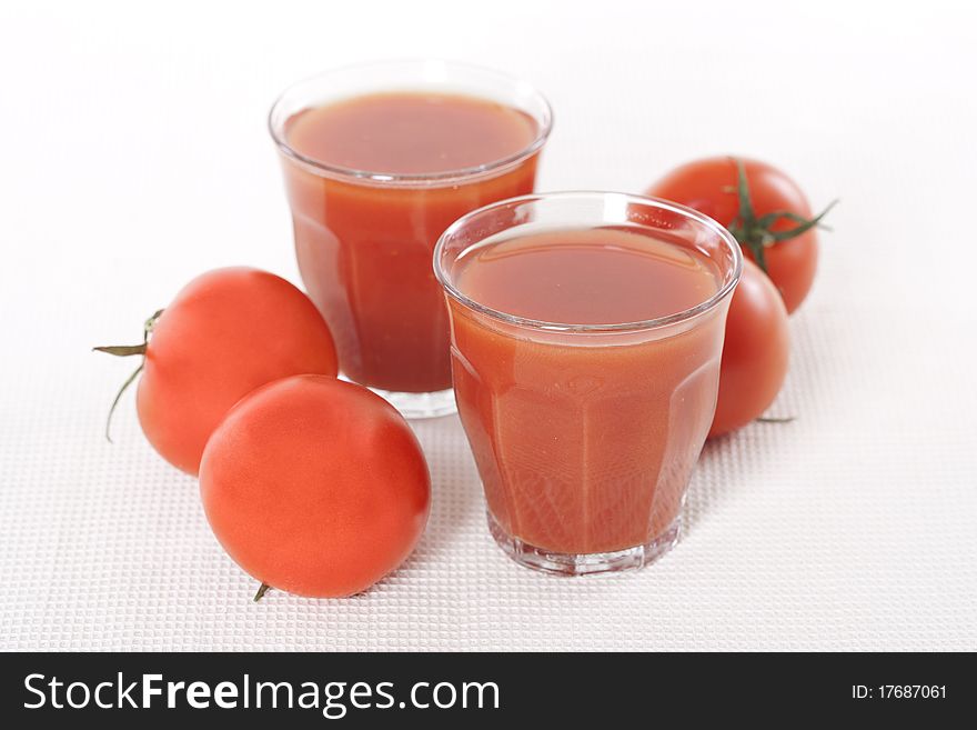 Fresh tomatoes and two glasses full of tomato juice. Fresh tomatoes and two glasses full of tomato juice