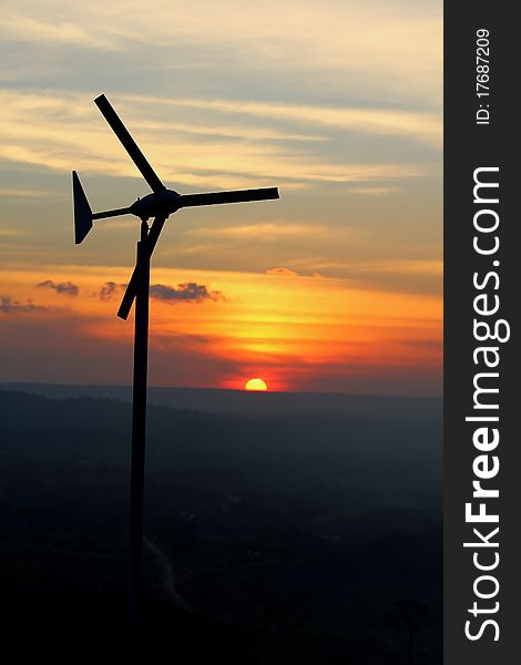 Wind turbine over sunset background