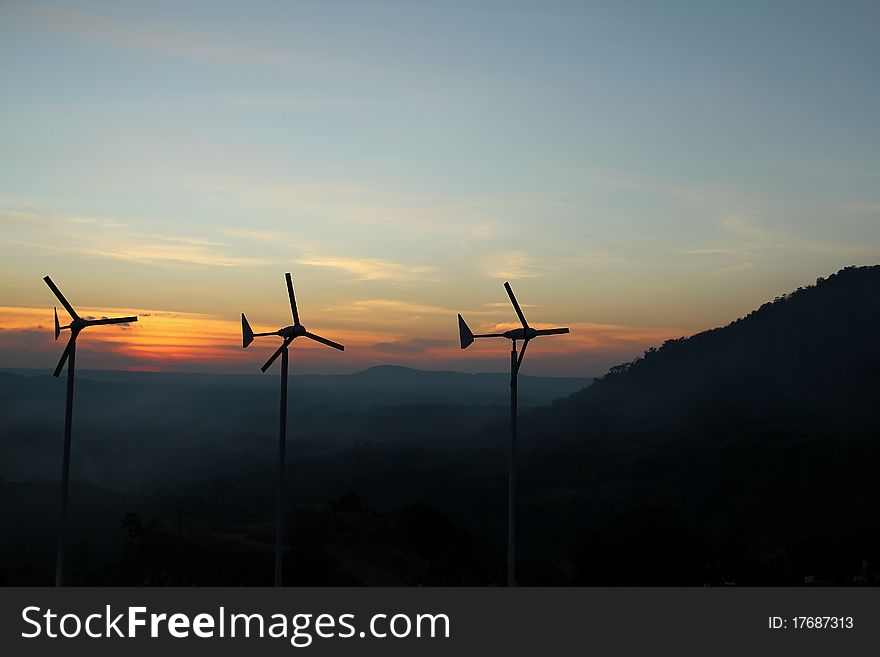 Wind turbine over sunset background