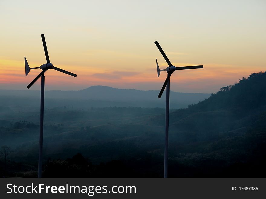 Wind turbine over sunset background