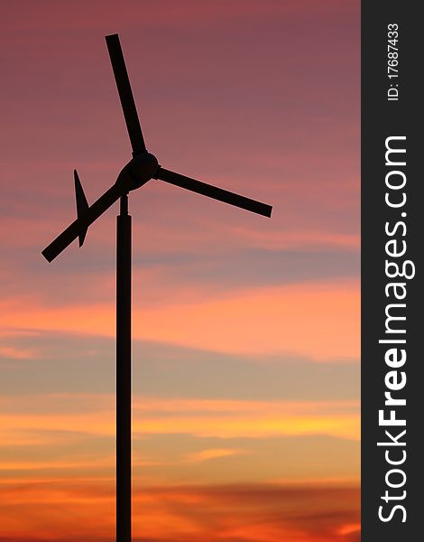 Wind turbine over sunset background