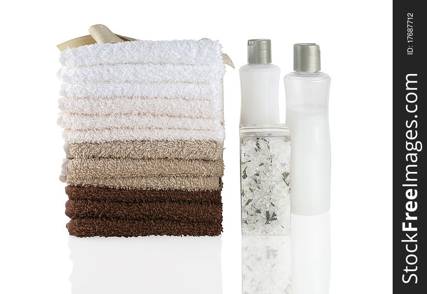 Stack of fresh wash cloths and bath products on a white reflective surface. Stack of fresh wash cloths and bath products on a white reflective surface