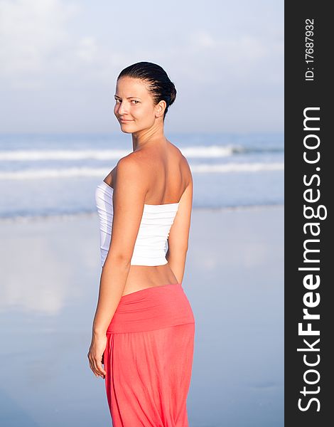 Beautiful woman relaxing by the seaside looking at the camera. Beautiful woman relaxing by the seaside looking at the camera