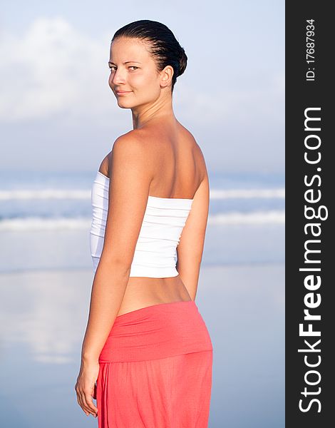 Beautiful woman relaxing by the seaside looking at camera. Beautiful woman relaxing by the seaside looking at camera