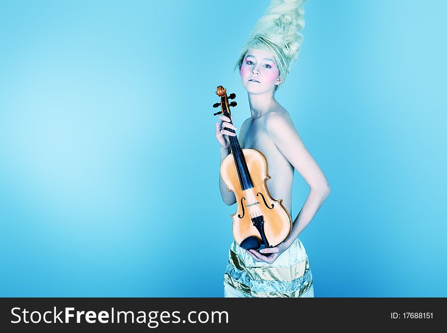 Portrait of an artistic young woman posing with violin. Shot in a studio. Portrait of an artistic young woman posing with violin. Shot in a studio.