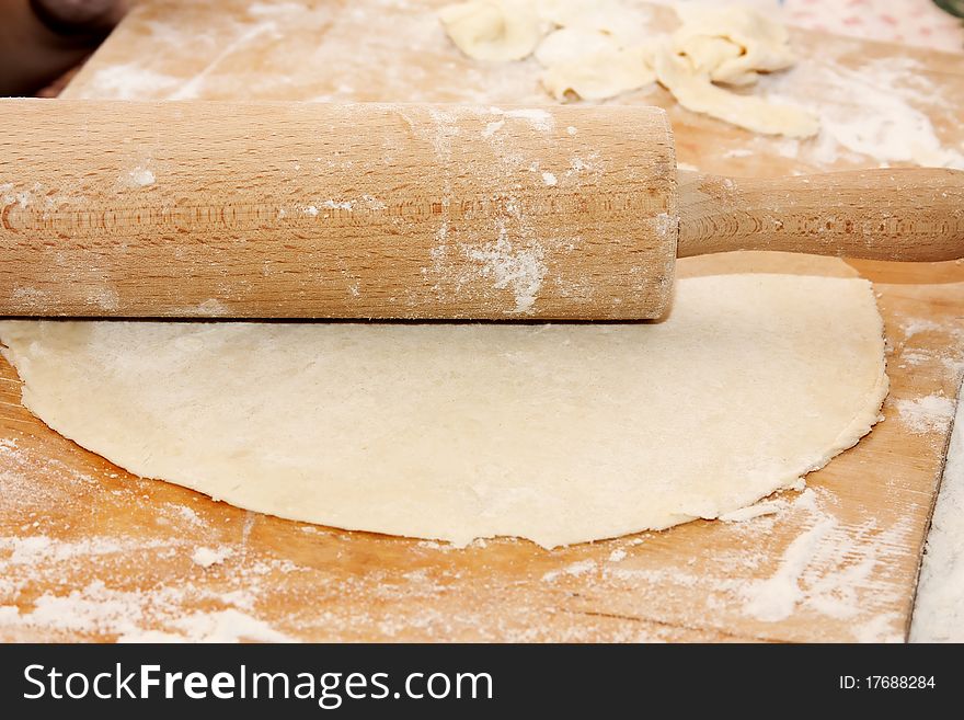 Thin layer of raw dough on wood background