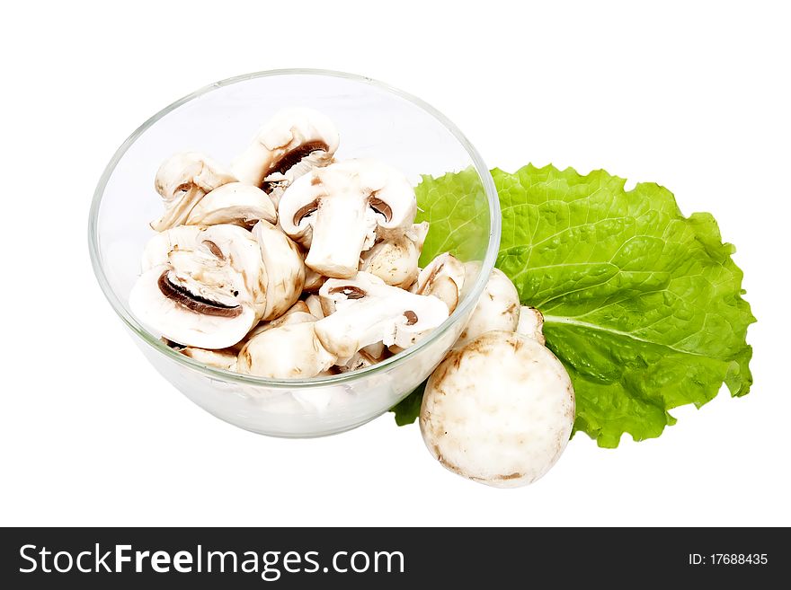 Mushrooms, sliced into pieces, in a glass bowl. Mushrooms, sliced into pieces, in a glass bowl