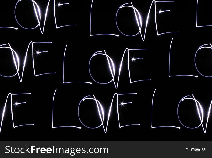 Word love drawn with a lantern light in a black wall