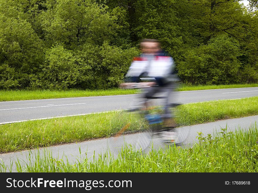 Blurred Man Riding Bicycles Along a Country Road