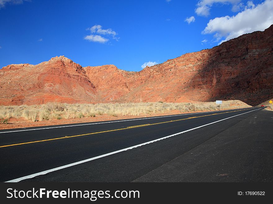 Road with red desert mountain and Cloudy Blue Skies in america
