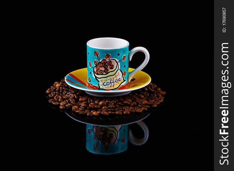 Colourful coffee cup and saucer  on roasted  beans