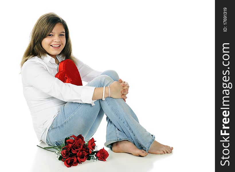 A beautiful young teen happy with her heart-shaped box of chocolates and a bouquet of red roses.  Isolated on white. A beautiful young teen happy with her heart-shaped box of chocolates and a bouquet of red roses.  Isolated on white.