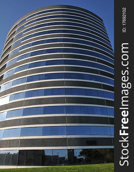 Large round office building with grass and blue sky. Large round office building with grass and blue sky.