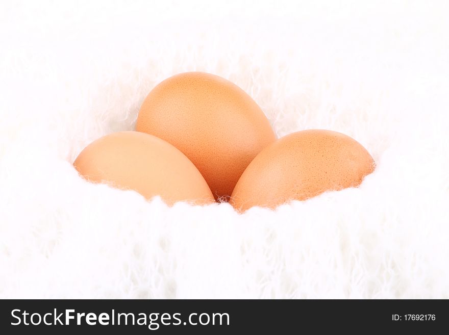 Three eggs lying down on a white background