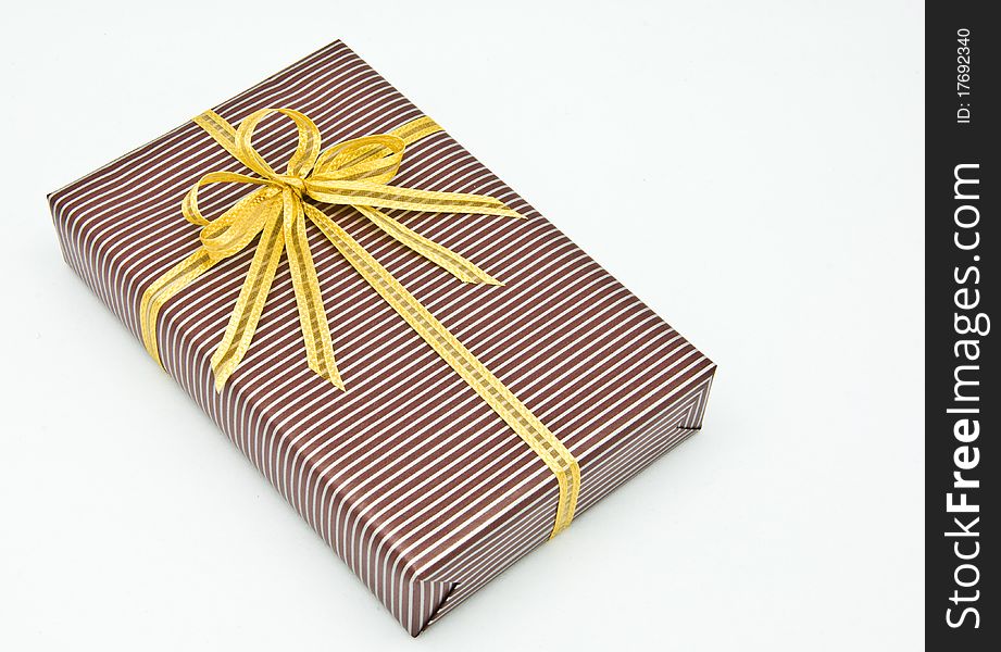 Black gift box with white bar attached gold ribbon on white background.