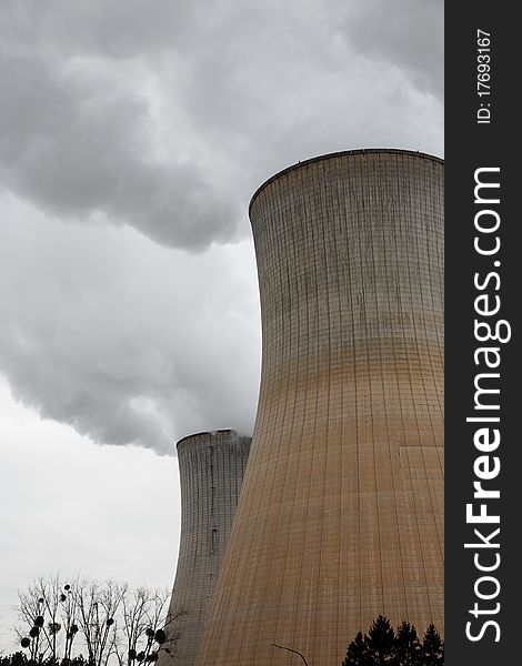 Two Steaming Cooling Towers and bare tree. Two Steaming Cooling Towers and bare tree