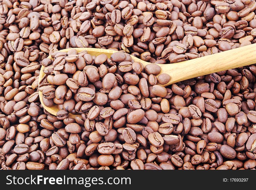 Full wooden spoon of caffee beans. Full wooden spoon of caffee beans.