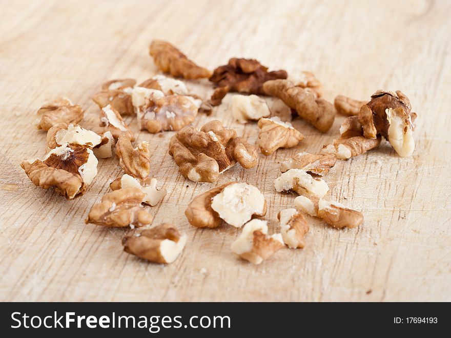 Cracked walnuts on wooden board