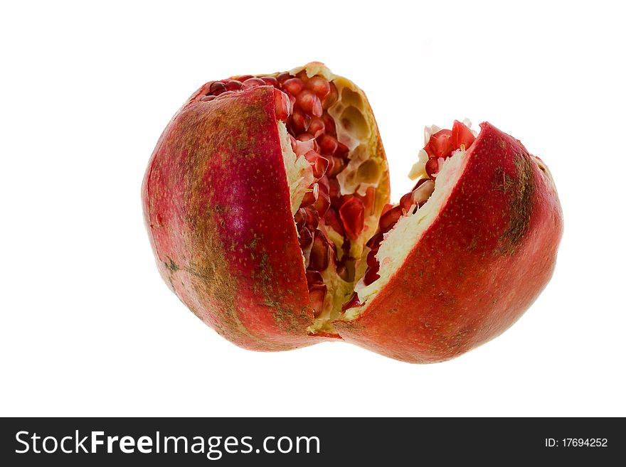 Mature pomegranate which have broken on two half (focus on the foreground, isolated)