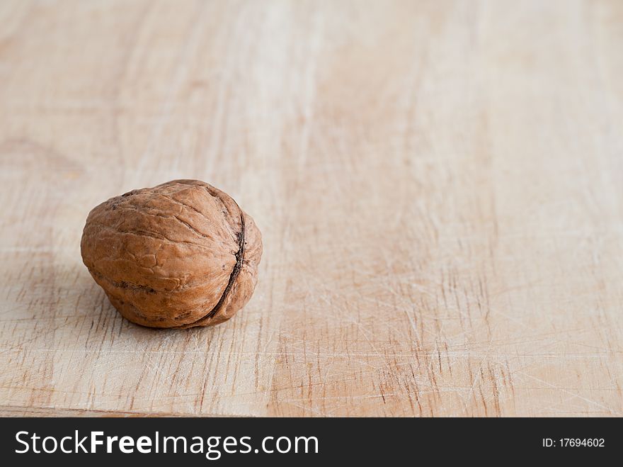 Single walnut on wooden board