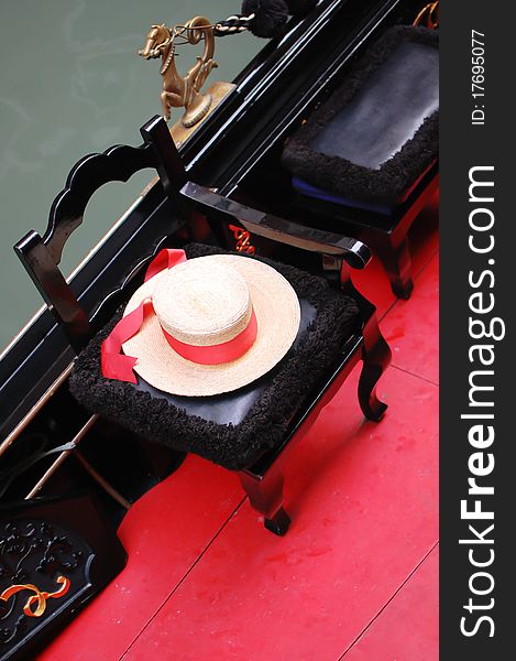 A close up shot from an elegant gondola seat with a gondolier’s straw-hat with red ribbon, Venice, Italy. A close up shot from an elegant gondola seat with a gondolier’s straw-hat with red ribbon, Venice, Italy