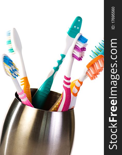 A group of toothbrushes in metal cup
